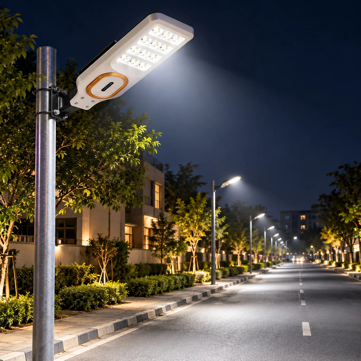A modern solar street light mounted on a metal pole, casting a bright beam of light down a quiet residential road at night.