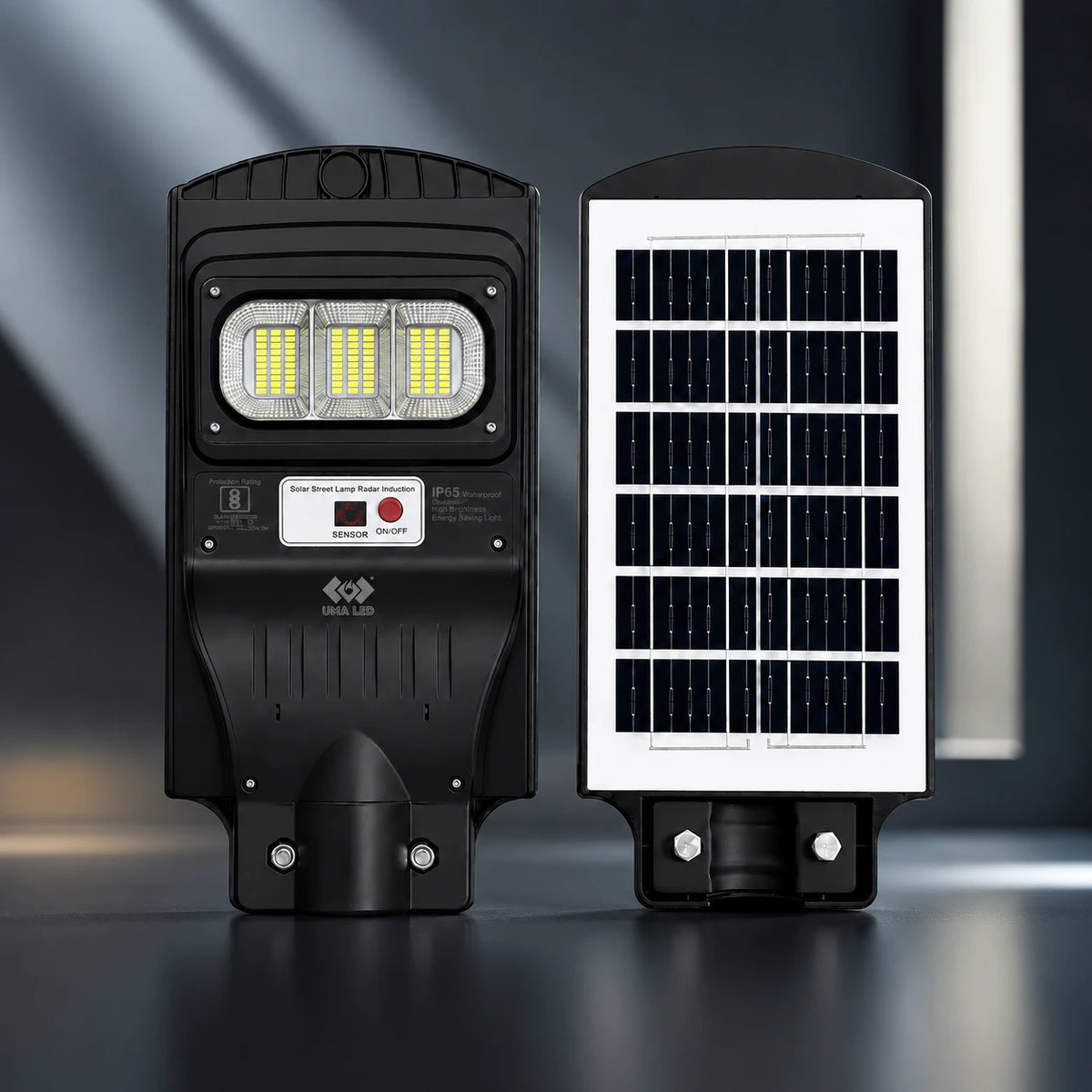 Two black solar-powered LED streetlights shown side by side on a dark reflective surface. The left unit shows the front with three illuminated LED light bars and a small control panel.