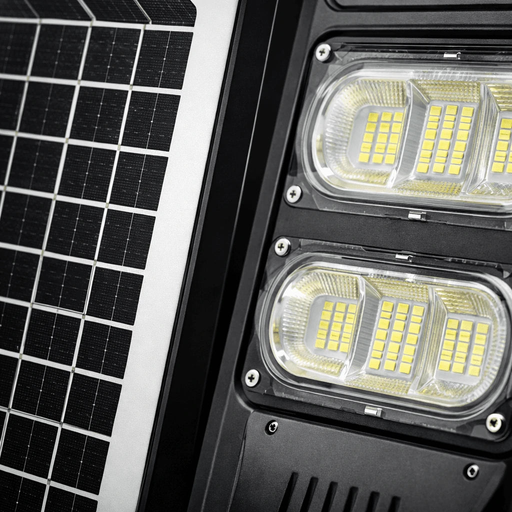 Close-up of a solar-powered LED light fixture showing a black solar panel on the left and two illuminated LED light modules on the right.