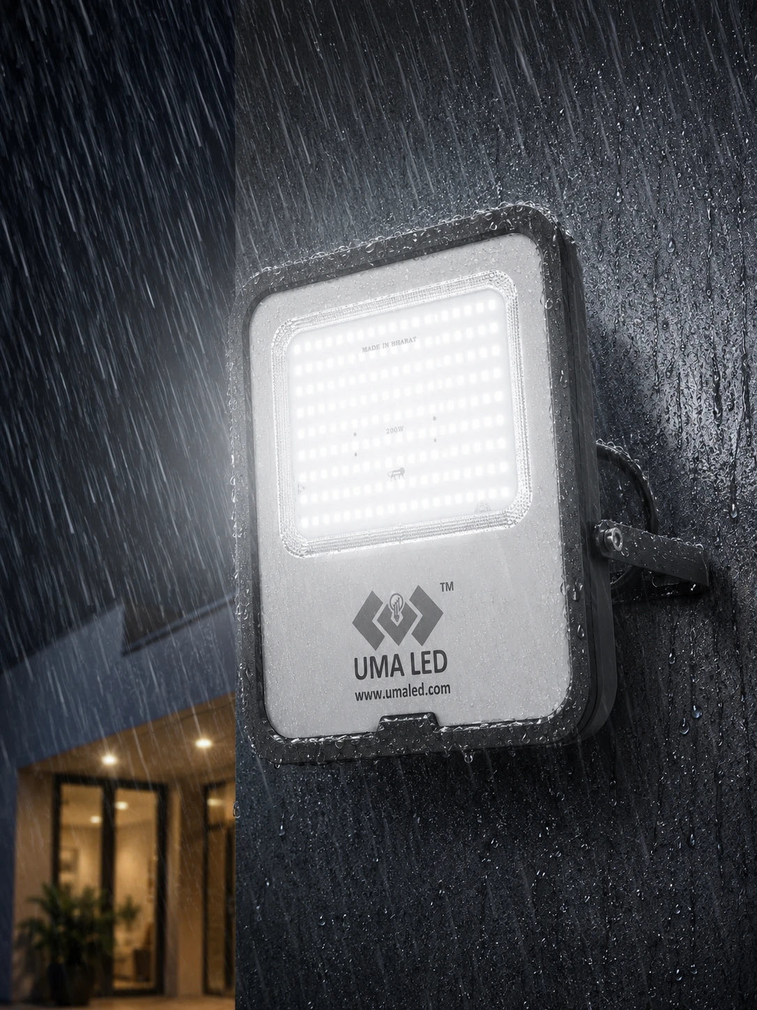 A waterproof UMA LED outdoor wall light fixture mounted on a dark wet wall, shown illuminated against a rainy night scene.
